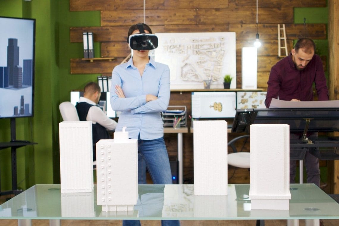 Female architects exploring virtual reality project of business buildings