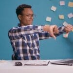 Office employee giving thumbs down in front of laptop screen