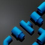 Set of blue PVC pipe fittings isolated on dark background. Blue plastic water pipe. PVC accessories