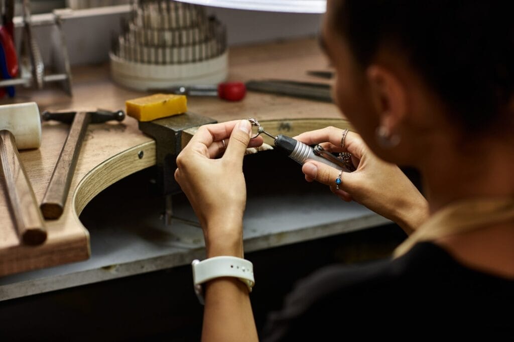 A skilled artisan meticulously crafting an exquisite jewel in a creative workshop